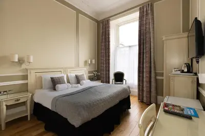 a bedroom with a large bed and a window at The Haymarket Hotel in Edinburgh