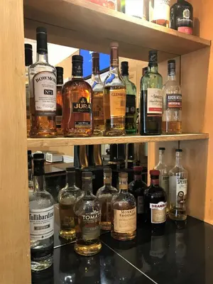 a shelf filled with lots of bottles of whiskey at The Haymarket Hotel in Edinburgh