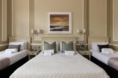 a hotel room with two beds and a painting on the wall at The Haymarket Hotel in Edinburgh