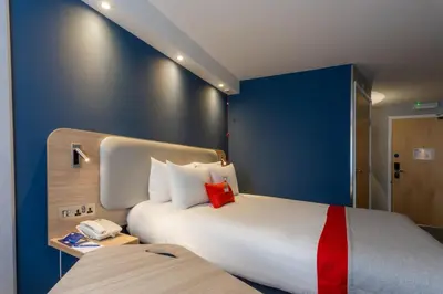 a hotel room with a large bed and a phone at Holiday Inn Express - Glasgow - City Ctr Theatreland by IHG in Glasgow