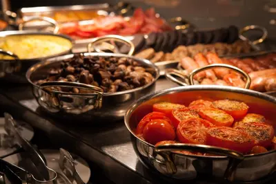 a buffet of different types of food in pans at Holiday Inn - Glasgow - City Ctr Theatreland by IHG in Glasgow