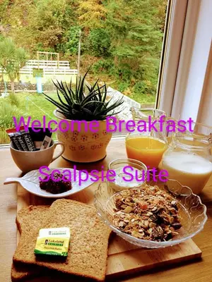 a table with a breakfast of bread and eggs at Commodore Guesthouse, Seaside Holiday Suites in Rothesay