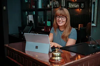a woman sitting at a table with a laptop computer at Angels Share Hotel in Edinburgh