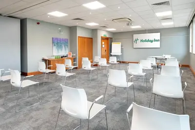a waiting room with white chairs and a presentation at Holiday Inn Edinburgh Zoo by IHG in Edinburgh