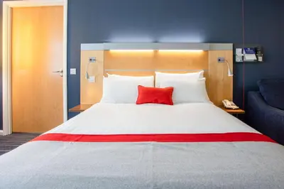 a red pillow on a bed in a hotel room at Holiday Inn Express Dunfermline by IHG in Dunfermline