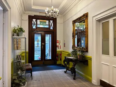 a hallway with a door and a table and a mirror at Safestay Glasgow Charing Cross in Glasgow