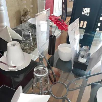 a glass table with a vase with a red flower on it at Beechwood Ensuite Guest House in Ayr