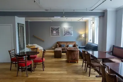 a living room with tables and chairs and a couch at Rosslea Hall Hotel in Rhu