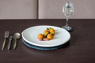 a plate of food on a table with a wine glass at Rosslea Hall Hotel in Rhu