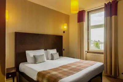 a bedroom with a large bed with a window at Rosslea Hall Hotel in Rhu