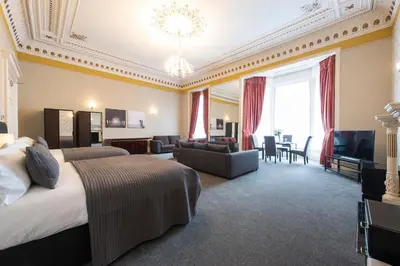 a hotel room with a bed and a living room at Grosvenor Suites in Edinburgh