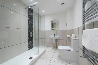 a white bathroom with a toilet and a sink at Grosvenor Suites in Edinburgh
