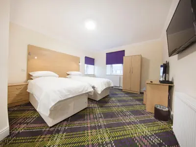 a hotel room with two beds and a flat screen tv at The Bay Horse in Hamilton