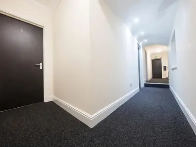 an empty hallway with a black door in a building at The Bay Horse in Hamilton