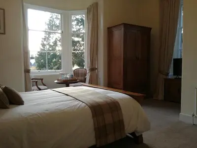 a bedroom with a bed and a large window at Lubnaig Guest House in Callander