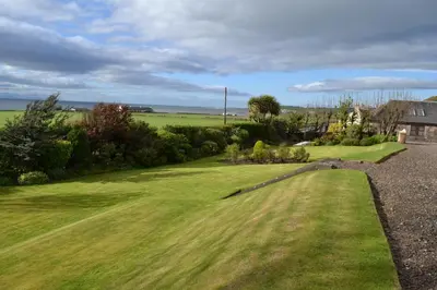 a view of a lawn with a house in the background at Burnside Farm B & B in Girvan