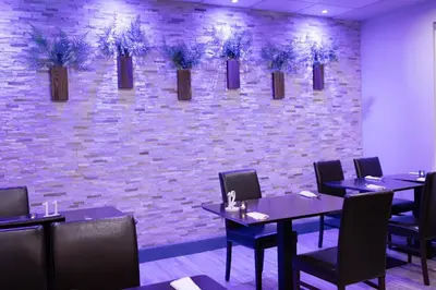 a restaurant with tables and chairs and a brick wall at The County Hotel in Helensburgh