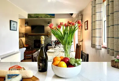 a vase of flowers and a bowl of fruit on a table at Alder Cottage in Blairmore