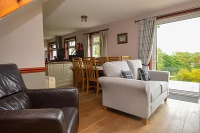 a living room with a couch and a chair at Larch Cottage in Blairmore