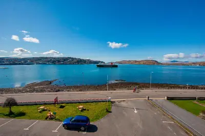 a car parked in a parking lot next to a lake at Muthu Alexandra Hotel in Oban