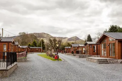 a gravel road in a village with wooden houses at Thistle Lodge in Auchterarder
