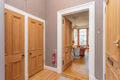 a hallway with wooden doors and a living room at South Learmonth Gardens Apartment in Edinburgh