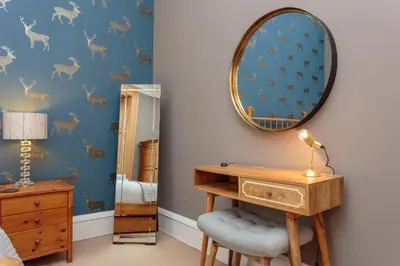a bedroom with a desk and a mirror at South Learmonth Gardens Apartment in Edinburgh