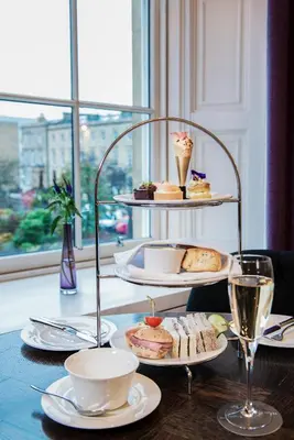 a table with plates of food and glasses of wine at Kimpton Blythswood Square Hotel & Spa by IHG in Glasgow