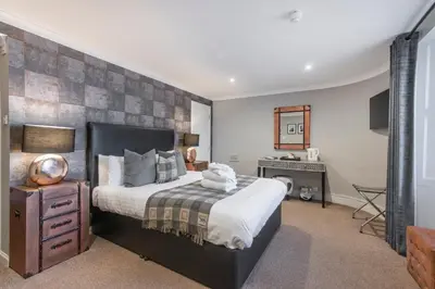 a bedroom with a large bed and a fireplace at The Allan Park in Stirling