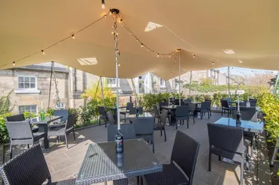 a patio with tables and chairs under a tent at The Allan Park in Stirling