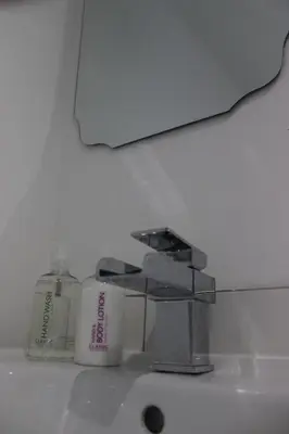 a bathroom sink with a faucet and a bottle of soap at Cobbler's Cottage in Dunblane