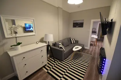 a living room with a chair and a dresser at Slateford House Apartment Ground Floor Main Door in Edinburgh