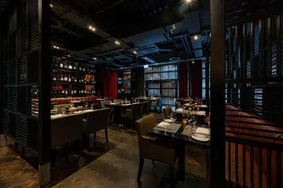 a restaurant with tables and chairs and wine bottles at Dakota Edinburgh in Queensferry