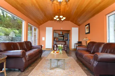 a living room with leather furniture and a wooden ceiling at Taigh na Mara in Kames