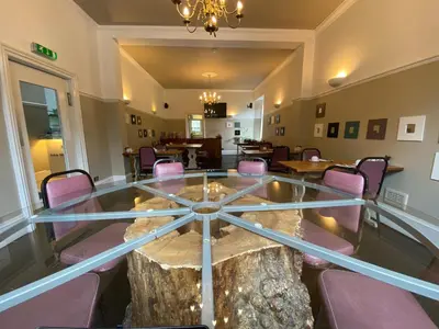 a room with a glass table with a tree stump inside at Auld Mill House Hotel in Dunfermline
