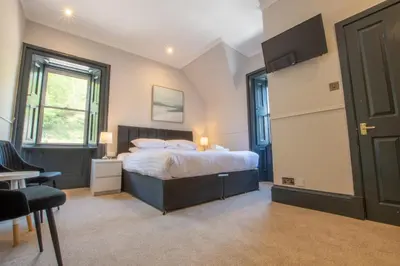 a bedroom with a bed and a desk and a window at Dalrigh House in Oban