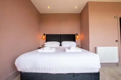 a bedroom with a large white bed with two towels at Dalrigh House in Oban