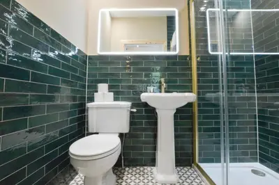 a green tiled bathroom with a toilet and a sink at Dalrigh House in Oban