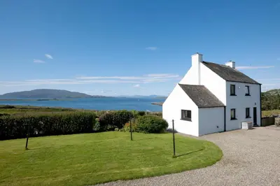 a white house with a view of the ocean at Aird Farm Holiday Cottages in Ardfern