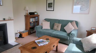a living room with a green couch and a coffee table at Aird Farm Holiday Cottages in Ardfern