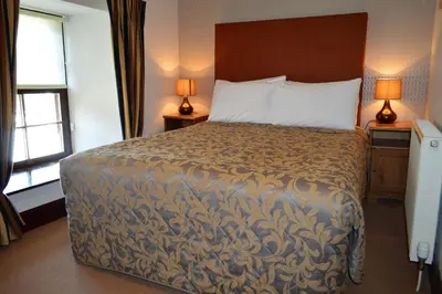a bed in a hotel room with two lamps at Culzean House in Ardentinny