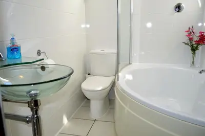 a bathroom with a sink and a toilet and a tub at Culzean House in Ardentinny