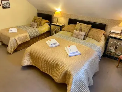 a bedroom with two beds with towels on them at Rosebank House Bed & Breakfast in Strathyre