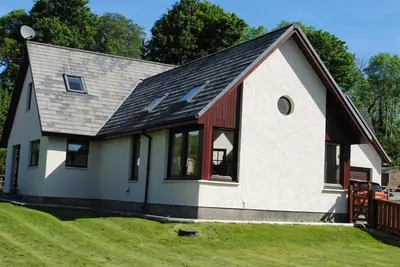 a small white house with a gambrel roof at Garbhein Bed & Breakfast in Kilmelford