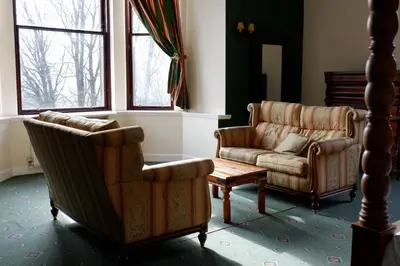 two chairs and a couch in a living room at Broomhall Castle Hotel in Stirling