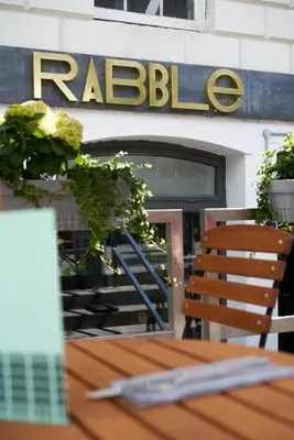 a table in front of a restaurant with a sign at Rabble in Edinburgh