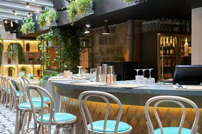 a restaurant with chairs and a bar with wine bottles at Rabble in Edinburgh