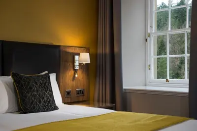 a bedroom with a bed and a window at New Lanark Mill Hotel in Lanark