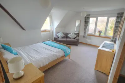 a small bedroom with a bed and a couch at ArdFyne on Lochfyne in Strachur