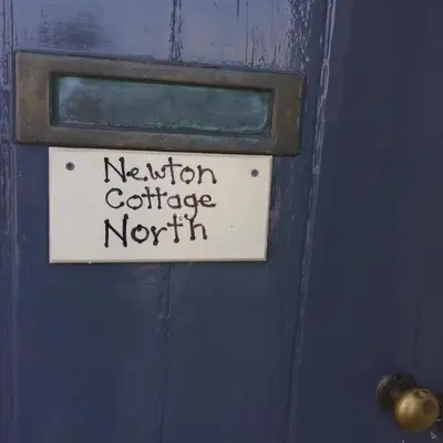 a sign on a blue door with the words neuron cartilage north at Newton Cottage North in Inveraray